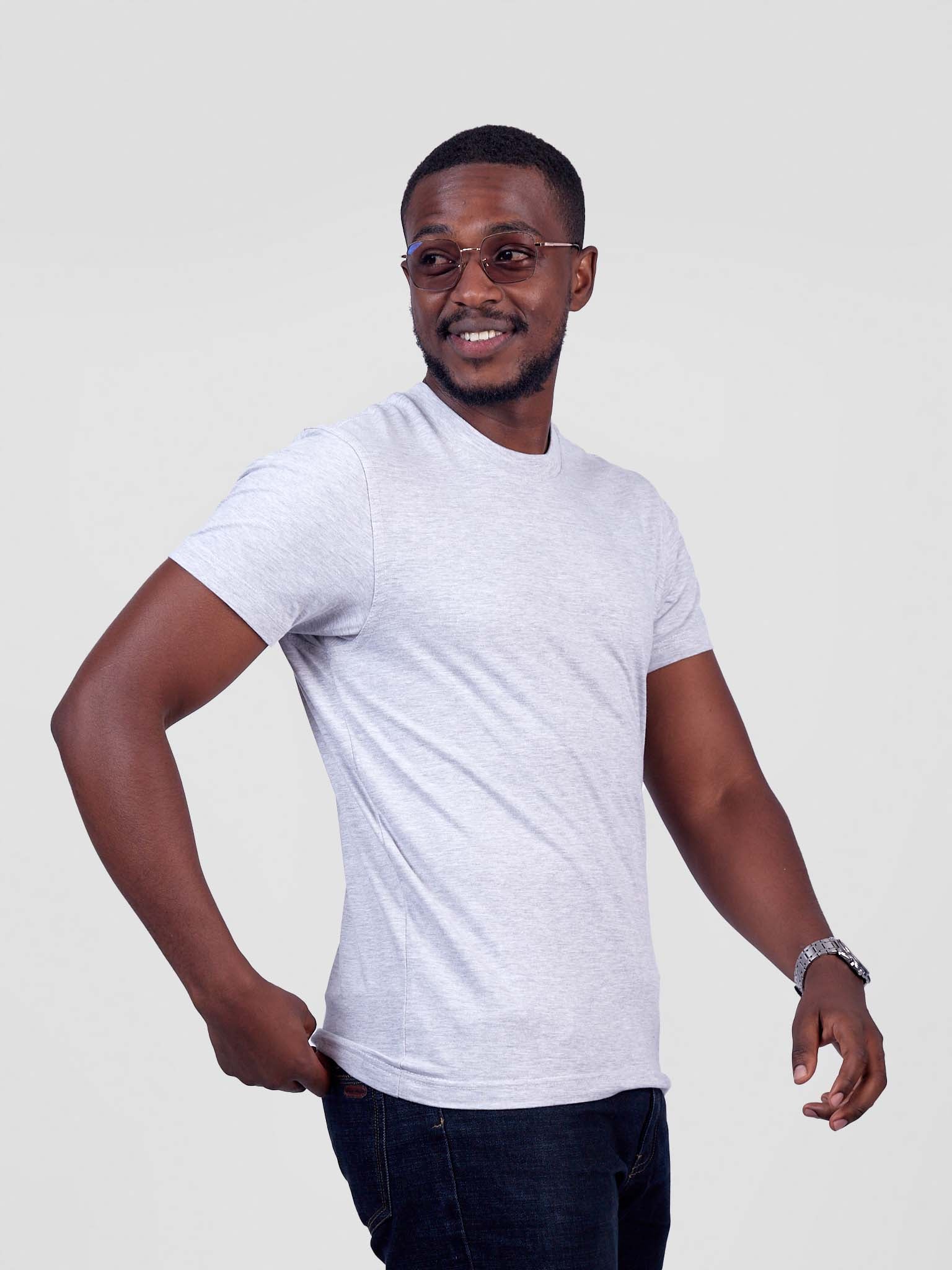A person wearing a white roundneck plain T-Shirt and black pants.